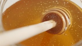 Wooden dipper in sweet food substance 4K 2160p 30fps UltraHD footage - Close-up of kitchen spiral utensil in glass honey jar 3840X2160 UHD video