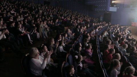 Children applauding in the auditorium during the performance. Theater for young spectators, Russia, Saratov, April 28, 2017.
