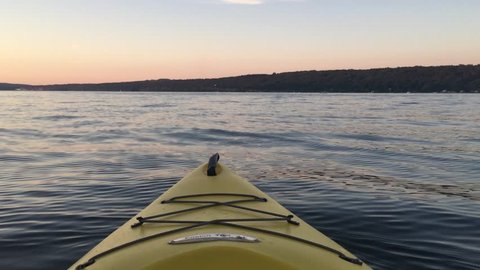 Kayaking on Lake at Twilight - a first person perspective of a yellow kayak floating on Cayuga Lake in the Finger Lakes of New York State during twilight.  Resting Meditation in Kayak on Lake.  