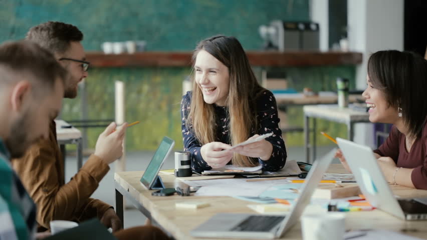 Creative business team meeting in modern office. Mixed race group of young people discussing start-up ideas, laughing. | Shutterstock HD Video #26337803