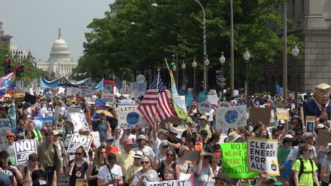 WASHINGTON, DC – APR. 29, 2017: Capitol in background, People's Climate March massive crowd protesting  Donald Trump’s environmental protection rollbacks, march on Pennsylvania Ave. to White House.