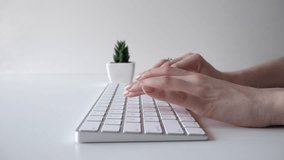 Female hands typing on a keyboard. Minimalistic white video 4K