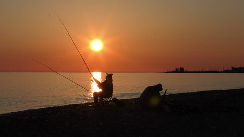 Beautiful scene with fisherman silhouette with rod sitting on sea beach