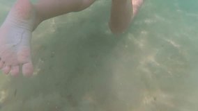 Child swims cheerfully in seawater on summer sunny day.  Real time full hd video footage shot with action camera.