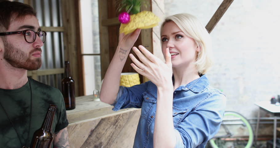 Young adult female posing with a pineapple on her head