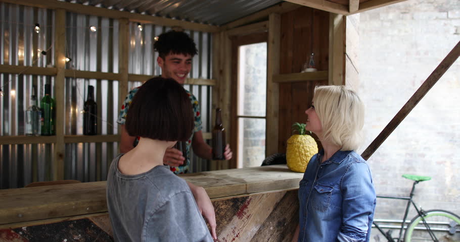 Two friends at a street food bar being served beer