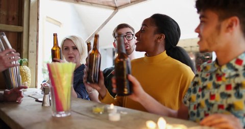 Group of friends at a street food bar saying cheers with beer