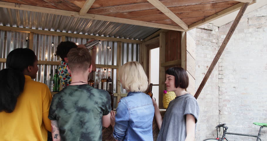Group of friends at a street food bar saying cheers with beer