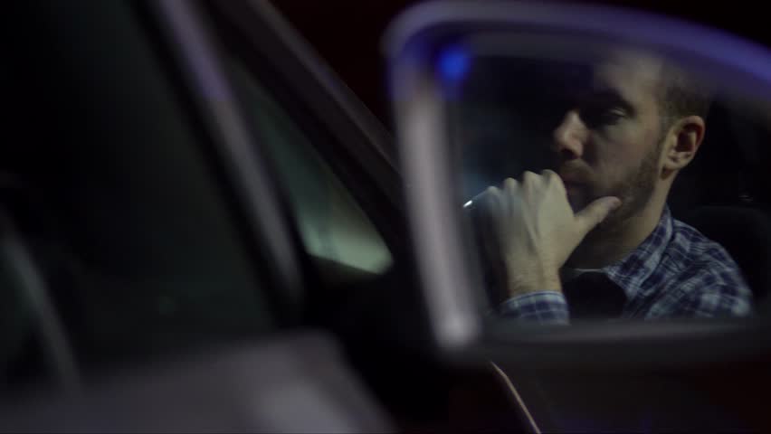Driver reacts on highway to getting caught by the police for drink driving and / or speeding. Reaction in wing mirror with sirens reflecting. Crime, law and order Royalty-Free Stock Footage #26358029