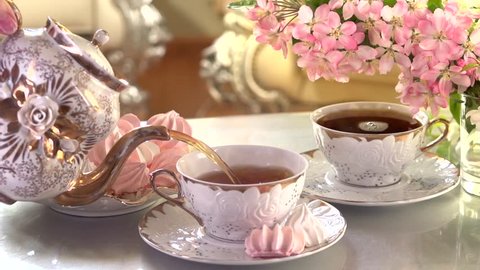 Tea Pouring. Porcelain cup of Healthy Tea closeup. Slow motion video footage 240fps 