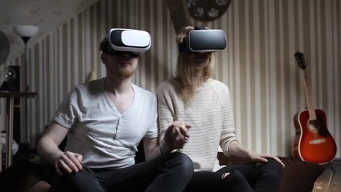 Couple Play a Roller Coaster in Virtual Reality Glasses in the Game Room