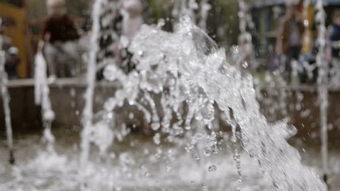Water jet slow motion. Water drops and splashes fly in an air. City park fountain working slomo footage.