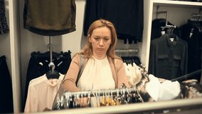 Woman shopping in clothes store, choose clothes
