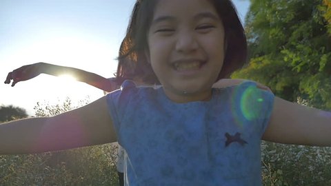 Slow motion of Happy Asian girl walking with her sister in the flower field with sunlight