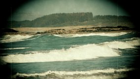 Old fashioned film video of waves on a quiet beach