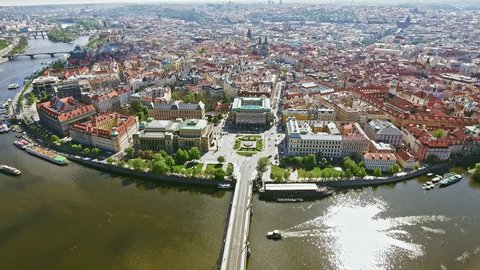 Aerial Bird Eye View of Prague Center Old Town Cityscape in Czech Republic feat. Vltava River and Boats on a Sunny Day in 4K Ultra HD