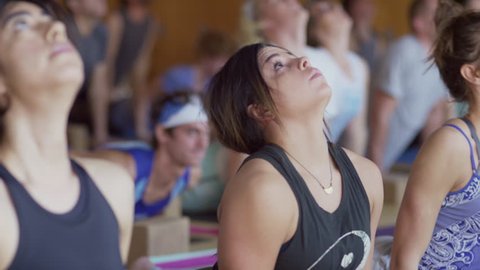 Close up slow motion shot of yoga class changing poses / Provo, Utah, United States