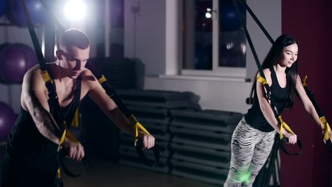 Man is engaged in trx exercises in the studio