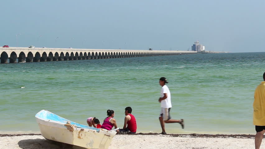 PROGRESO, MEXICO - CIRCA JULY 2012: Beach goers relax near the 4 mile long pier