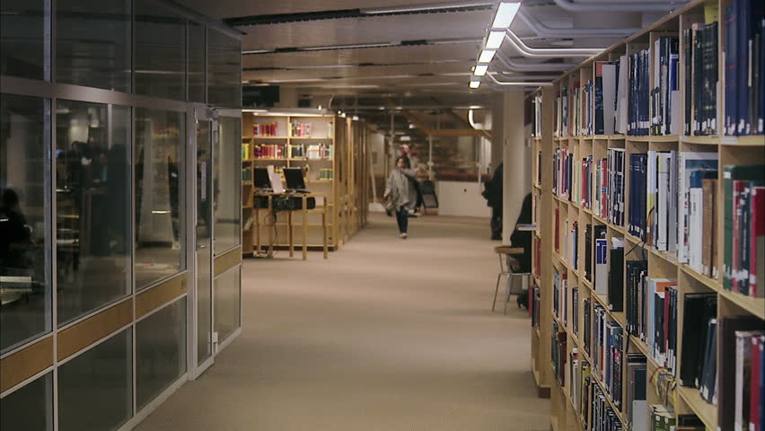 Students walking arm-in-arm in a library, Sweden.