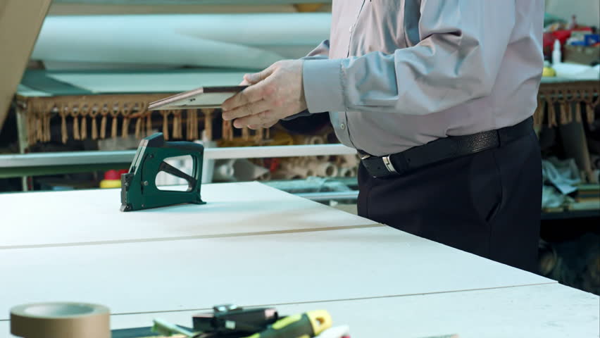 Young male trainee and senior business owner talking and smiling in workshop