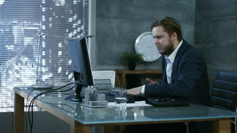 In a Private Office Businessman Loses Temper and Hits His Monitor With Keyboard, in an Act of a Rage Throws everything off the Table. Shot on RED EPIC-W 8K Helium Cinema Camera.