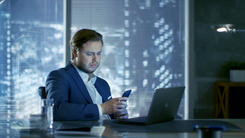 Successful Young Businessman Sits in a Private Office At His Desk and Works on a Laptop. Behind Him Window with Big City View. Shot on RED EPIC-W 8K Helium Cinema Camera. | Shutterstock HD Video #26432105