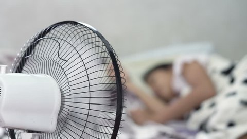 Little girl sleeping with fan blowing
