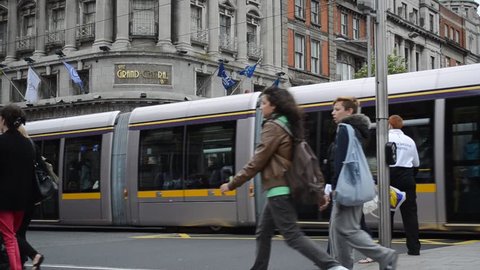 DUBLIN, IRELAND - CIRCA 2011: Public transport tram system (LUAS) and people crossing the intersection circa 2011 in downtown Dublin, Ireland.