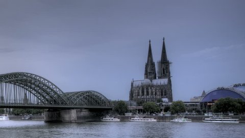 HDR Time lapse Riverside view of the Cologne Cathedral and railway bridge over the Rhine river, Germany 