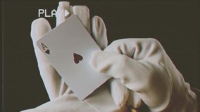 Fake VHS tape: a glove-covered hand showing a playing card (ace of hearts). Moody, mysterious medium shot. Many takes.
 - Powered by Shutterstock - Get 15% off with code: PIKWIZARD15