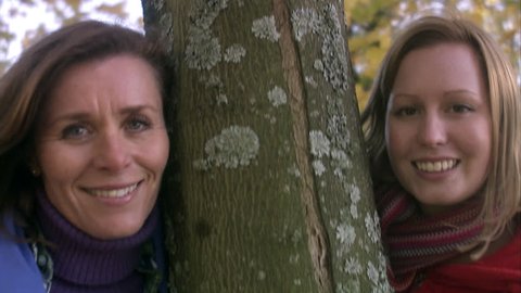 Two women and a tree trunk