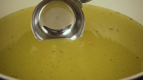 Slow motion. Scoop up and pour the clear broth from the pan with a small ladle
