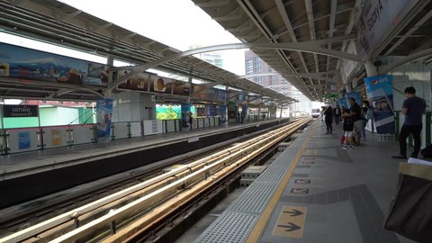 Footage of the scene of people getting on the Sky train at noon time at Ekkamai Station, Sukhumvit 63, Bangkok, Thailand, April 2017