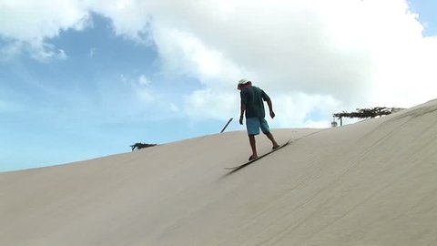 Man surfung on a sand in Jericoacoara, Brazil