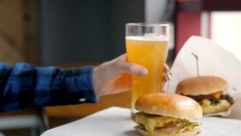 Hamburger,burger, a glass of beer and cutlery on the background of the hall cafe.