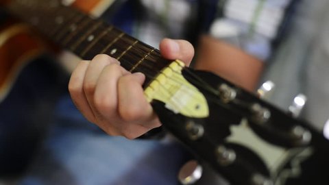Locked-on shot of a man playing a guitar