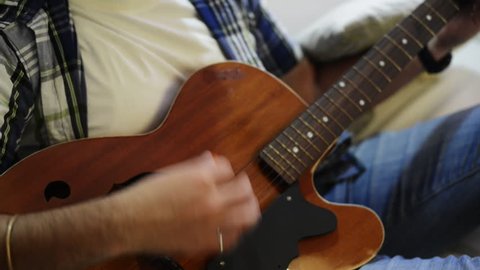Tilt up shot of a man playing a guitar
