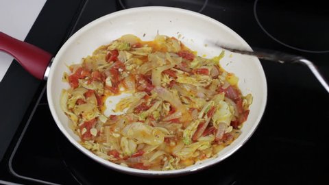 Person Cooking and Stirring Vegetables in a Pan
Tomatoes, onions, napa cabbage, and onions being cooked and stirred in a non-stick frying pan. Male preparing healthy vegetables in cookware on a stove
