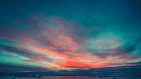 Antarctic Nature. Beautiful colorful sunset cloudy sky. Bright orange clouds reflected in ocean. Majestic polar landscape. Beauty world, holiday, sport and recreation. Travel background. Time lapse 4K