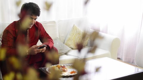 Pan shot of a man text messaging on a mobile phone at Raksha Bhandan festival