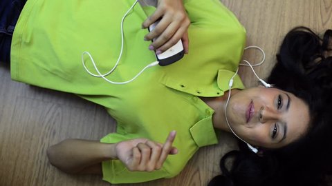 Pan shot of a woman listening to a mp3 player