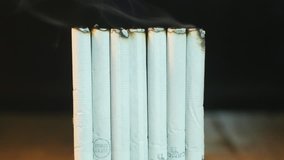 Cigarettes Burning Down and Up Timelapse - Closeup shot of cigarettes burning halfway down and then video reverses to show them returning to the former state