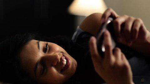 Pan shot of a woman text messaging on a mobile phone