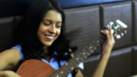 Zoom in shot of a woman playing a guitar