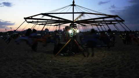 Locked-on shot of tourists enjoying in merry-go-round, Marina Beach, Mylapore, Chennai, Tamil Nadu, India