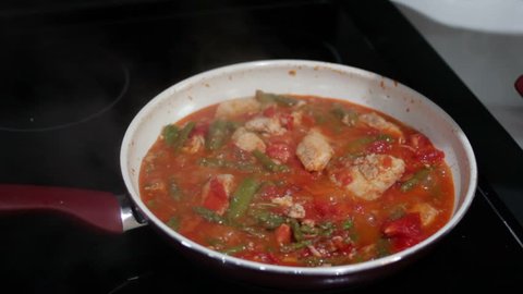 Cooking Tomatoes, Chicken and Asparagus in a Pan
Male hand stirring and cooking tomatoes, chicken and green asparagus in a pan. Vegetables and poultry simmering in a saucepan and stirred by a man.