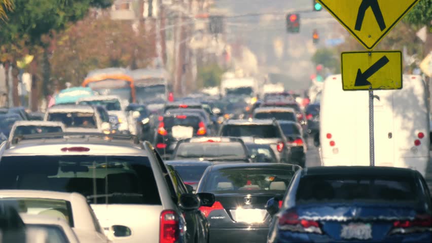 Telephoto shot of city street crowded with cars stuck in traffic jam on a hot day, seen through hot air turbulence. Los Angeles, California. 4K UHD, slow motion. Royalty-Free Stock Footage #26480198
