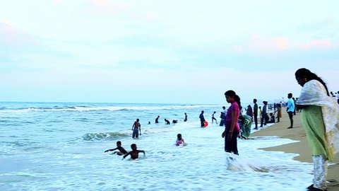 TAMIL NADU, INDIA - JUNE 2012: Pan shot of tourists enjoying on the beach, Marina Beach, Bay Of Bengal, Mylapore, Chennai, Tamil Nadu, India