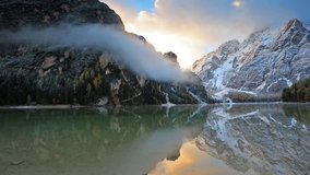 Misty morning on Braies Lake with Seekofel mount on background. Colorful autumn landscape in Italian Alps, Naturpark Fanes-Sennes-Prags, Dolomite, Italy, Europe. Full HD video (High Definition).